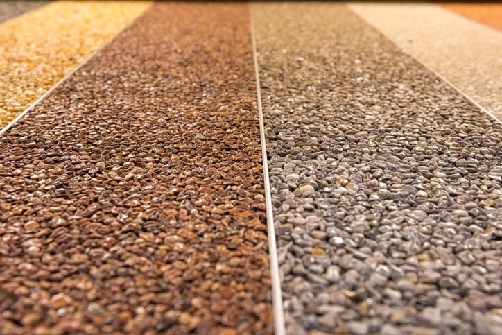 Close up of a natural stone carpet. Decorative stone coating. Slip resistant floor finish containing natural stone particles. Set of various types and colors.